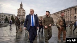 In this image provided by the Ukrainian Presidential Press Office, Ukrainian President Volodymyr Zelenskyy, center right, and Britain's Prime Minister Boris Johnson, center left, walk during Johnson's visit, in downtown Kyiv, Ukraine, April 9, 2022.