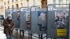 Un homme passe devant des affiches de campagne déchirées près d'un bureau de vote, à Paris, France, le 10 avril 2022. 