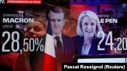 Les résultats des élections avec les deux candidats du second tour de l'élection présidentielle française de 2022 sont vus sur un écran au lieu de réunion de Marine Le Pen, à Paris, en France, le 10 avril 2022. 