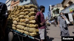 A man stands by a cart with potatoes at a market, amid the country's economic crisis in Colombo, Sri Lanka, April 7, 2022.
