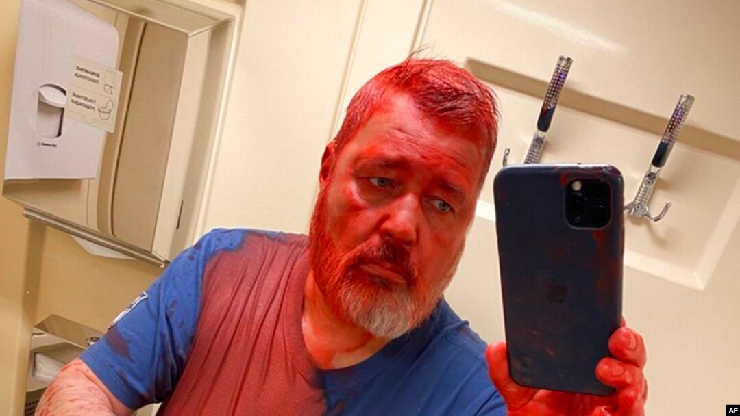 Redaktur surat kabar Novaya Gazeta, Dmitry Muratov, yang juga peraih Nobel Perdamaian tahun lalu, mengambil selfie setelah disiram dengan cat merah oleh seseorang di kereta di Rusia, pada 7 April 2022. (Foto: Novaya Gazeta Europe's Telegram channel via AP)