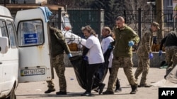 Ukrainian soldiers clear out bodies after a rocket attack killed at least 35 people on April 8, 2022 at a train station in Kramatorsk, eastern Ukraine, that was being used for civilian evacuations.