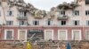 Dua perempuan di depan Hotel Ukraina yang hancur, sementara invasi Rusia terus berlangsung, di Chernihiv, Ukraina. 6 April 2022. 