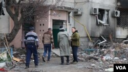 2022年4月6日，在乌克兰小镇博罗江卡，人们进入一座基本已被破坏的楼房，寻找也许仍然完好的个人财物。(美国之音希瑟·默多克拍摄)