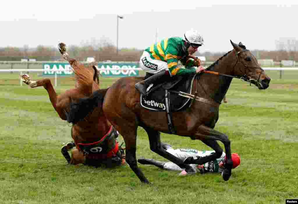 Epatante, ridden by Aidan Coleman, races on as Zanahiyr ridden by Jack Kennedy, falls during the Grand National Festival 2022 at the Aintree Racecourse, Liverpool, Britain.