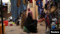 FILE - Women and children who fled attacks by Islamist militants in northern Burkina Faso are pictured at a camp for internally displaced people, in Ouagadougou, Burkina Faso, Jan. 29, 2022.