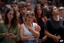 People gather to pay their respects at the site of a shooting attack the previous night, in Tel Aviv, Israel, April 8, 2022.