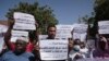FILE - Sudanese journalists protest in Khartoum, Sudan, Nov.16, 2021. Many of the placards read: "We stand with the masses against the military coup." 
