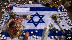 People light candles at the site of Thursday night's shooting attack, in Tel Aviv, Israel, April 8, 2022.