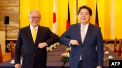 Japan's Foreign Minister Yoshimasa Hayashi, right, and Philippine Foreign Secretary Teodoro Locsin pose before a meeting at the Iikura Guest House in Tokyo on April 9, 2022.