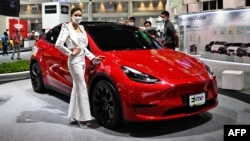 Seorang model mempromosikan mobil listrik Tesla Model Y di Bangkok International Motor Show di Bangkok pada 24 Maret 2022. (Foto: AFP/Lillian SUWANRUMPHA)