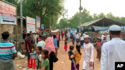 Pengungsi Rohingya berjalan di kamp pengungsi Rohingya Kutupalong di Ukhiya di distrik Cox's Bazar, Bangladesh, Minggu, 10 Oktober 2021. (Foto: AP)