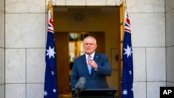 Perdana Menteri Australia Scott Morrison memberi isyarat selama konferensi pers di Gedung Parlemen di Canberra, Australia, 10 April 2022. (Foto: via AP)