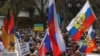 People with Ukrainian flags (background) protest against a pro-Russian march in Frankfurt am Main, western Germany, April 10, 2022.
