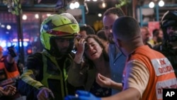 Una mujer reacciona en la escena de un tiroteo mortal en un bar de Tel Aviv, Israel, el 7 de abril de 2022.