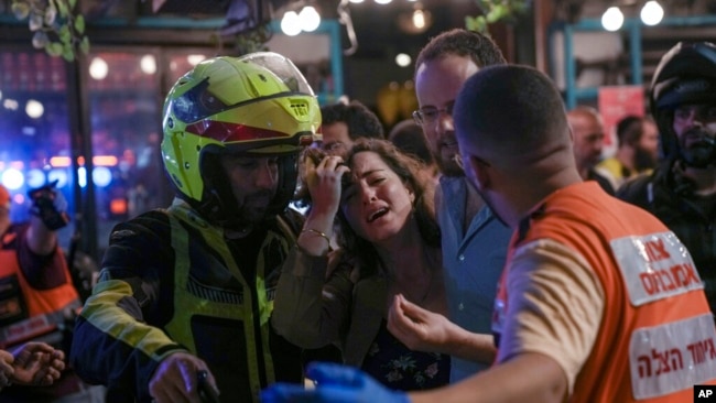 Una mujer reacciona en la escena de un tiroteo mortal en un bar de Tel Aviv, Israel, el 7 de abril de 2022.