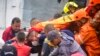 Los equipos de rescate cargan a un sobreviviente donde una ladera debilitada por la lluvia se derrumbó sobre las casas de las personas en Pereira, Colombia, el 8 de febrero de 2022. 