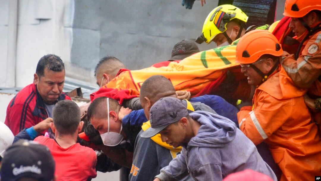 Los equipos de rescate cargan a un sobreviviente donde una ladera debilitada por la lluvia se derrumbó sobre las casas de las personas en Pereira, Colombia, el 8 de febrero de 2022. 