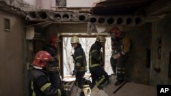 Los bomberos trabajan para proteger un edificio residencial previamente dañado por un ataque ruso en Kharkiv, Ucrania, el 9 de abril de 2022.