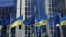 FILE - The flags of the European Union and Ukraine flutter outside the European Parliament building, in Brussels, Belgium, Feb. 28, 2022. 