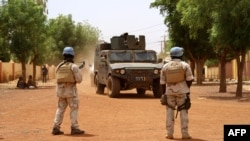 FILE - Soldiers of the U.N. peacekeeping mission in Mali MINUSMA patrol in the streets of Gao, Mali, July 24, 2019. Deteriorating security conditions in the northern area of Ber have forced an early exit of MINUSMA soldiers there. 