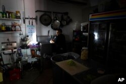 Employees at Las Palmas Cafe work with the power of an electricity generator during an island-wide blackout, in San Juan, Puerto Rico, April 7, 2022.