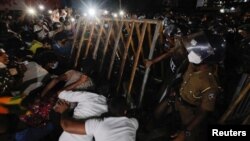 Police officers try to hold the metal barrier gates as demonstrators pull it off during a protest near Temple Trees Prime Minister Mahinda Rajapaksa's official residence, amid the country's economic crisis in Colombo, Sri Lanka, April 7, 2022.
