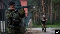 FILE - Russian-backed rebels guard their position near Marinka in the suburbs of Donetsk, Eastern Ukraine, Thursday, June 4, 2015.