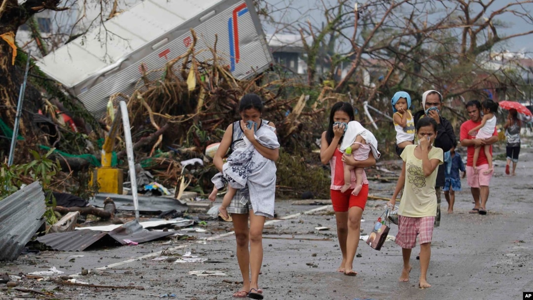 Warga yang selamat dari topan Haiyan di Tacloban, pulau Leyte menutup hidung akibat bau menyengat mayat para korban tewas (10/11). 