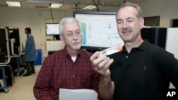 Timothy Ley , MD (left) and Richard Wilson, PhD, looking at a flow cell in the genome sequencing lab. They and their Washington University colleagues have shown the power of sequencing cancer patients' genomes as a diagnostic tool.