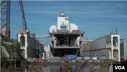 A Navy ship undergoes maintenance at a naval ship repair facility in Norfolk, Virginia. (Mary Cieslak/VOA)