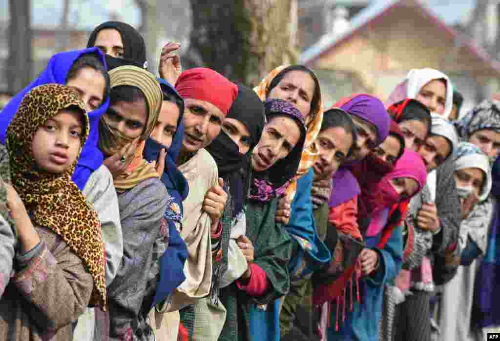 Kashmiri villagers look on during the funeral of militant commander Noor Mohammad Tantray in the Aripal village of Tral district, India.