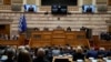 Ukrainian President Volodymyr Zelenskyy, on the screens, addresses the Greek Parliament in Athens, Greece, April 7, 2022.