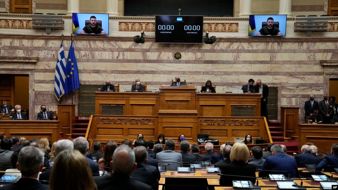 Ukrainian President Volodymyr Zelenskyy, on the screens, addresses the Greek Parliament in Athens, Greece, April 7, 2022.