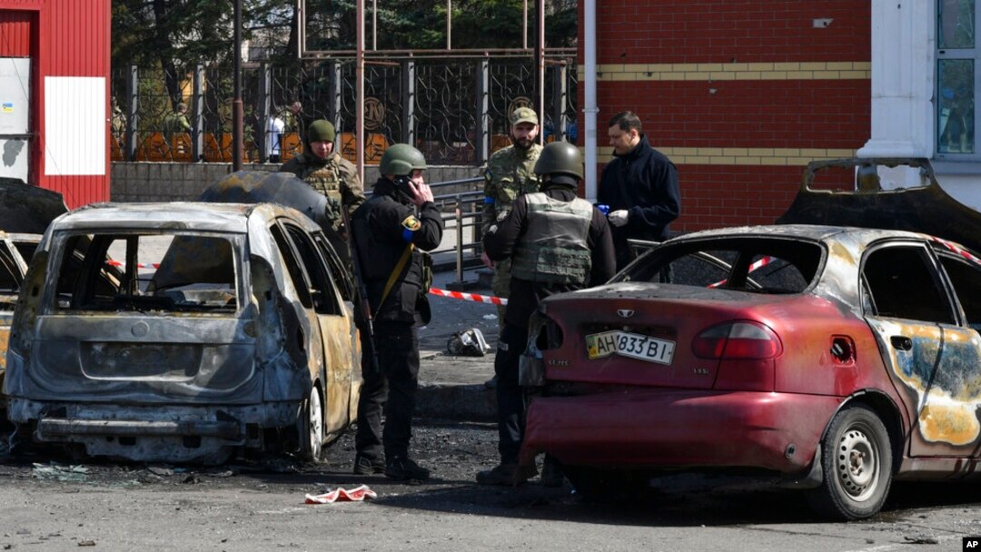Ukrainian servicemen stand next to damaged cars after Russian shelling at the railway station in Kramatorsk, Ukraine, April 8, 2022.