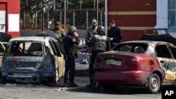 Ukrainian servicemen stand next to damaged cars after Russian shelling at the railway station in Kramatorsk, Ukraine, April 8, 2022.
