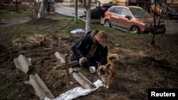 烏克蘭布查鎮一名男子在埋葬被俄軍殺死的朋友後在墓旁悲泣。 （2022年4月6日）