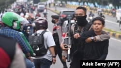 Polisi menangkap seorang pria saat unjuk rasa di Jakarta pada 11 April 2022. (Foto: AFP/Adek Berry)
