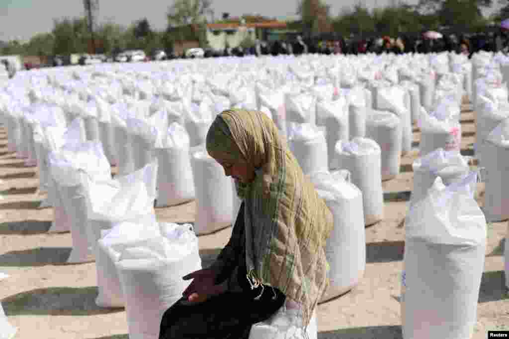 An Afghan girl waits to receive a rice sack, as part of humanitarian aid sent by China to Afghanistan, at a distribution center in Kabul, Afghanistan. (REUTERS/Ali Khara)