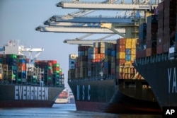 FILE - Container ship Ever Far, left, sails down river past the Georgia Ports Authority's Port of Savannah, Sept. 29, 2021, in Savannah, Ga.