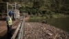 Lievin Chizungu, directeur de production de la centrale hydroélectrique Ruzizi 1, observe le niveau des déchets plastiques autour du barrage à Bukavu, dans l'est de la République démocratique du Congo, le 16 mars 2022.