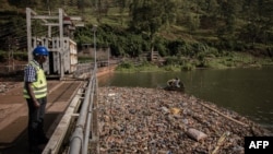 Lievin Chizungu, directeur de production de la centrale hydroélectrique Ruzizi 1, observe le niveau des déchets plastiques autour du barrage à Bukavu, dans l'est de la République démocratique du Congo, le 16 mars 2022.