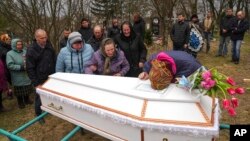 People mourn April 8, 2022, in Chernihiv region, Ukraine, at the funeral of Veronika Kuts, 12, who was killed during a Russian bombardment in Ukraine.