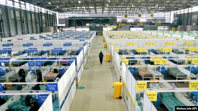 In this photo released by China's Xinhua News Agency, people with mild and asymptomatic cases of COVID-19 quarantine at the Shanghai New International Expo Center in Shanghai, Friday, April 1, 2022. (Ding Ting/Xinhua via AP)