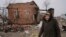 Жителька села Андріївка поруч зі зруйнованим будинком після звільнення села від окупації.  AP Photo. Автор Vadim Ghirda