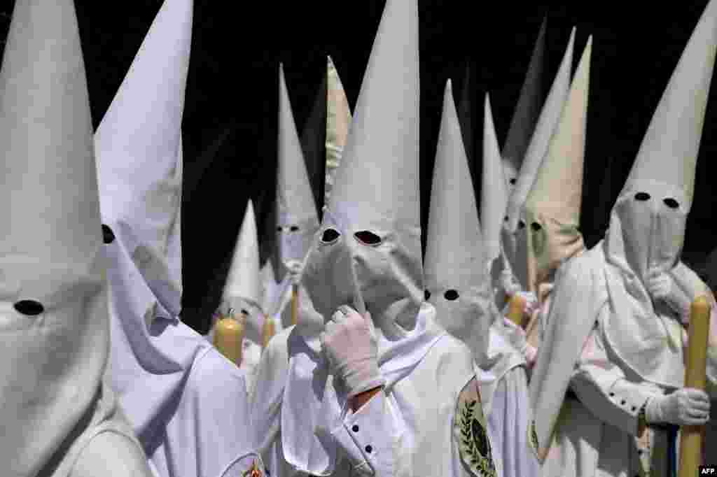 Penitents of &#39;La Paz&#39; brotherhood parade during the Holy Week&#39;s Palm Sunday procession in Seville, Spain.