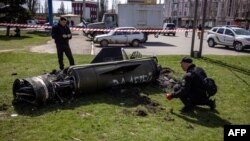 FILE - Ukrainian police inspect the remains of a large rocket with the words 'for our children' in Russian next to the main building of a train station in Kramatorsk, eastern Ukraine, that was hit by a rocket attack, killing at least 35 people, on April 8, 2022