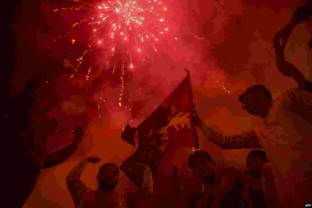 Pakistan Peoples&#39; Party (PPP) supporters celebrate on the street after a Supreme Court ruling in Karachi. (Photo by Asif HASSAN / AFP)