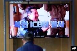 Seorang pria menonton layar TV yang menayangkan program berita tentang ICBM Korea Utara dengan gambar pemimpin Korea Utara Kim Jong Un di sebuah stasiun kereta api di Seoul, Korea Selatan, 25 Maret 2022. (Foto: AP)