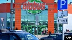 FILE - People walk past the German Globus retail food hypermarket in the town of Klimovsk outside Moscow on March 19, 2022.